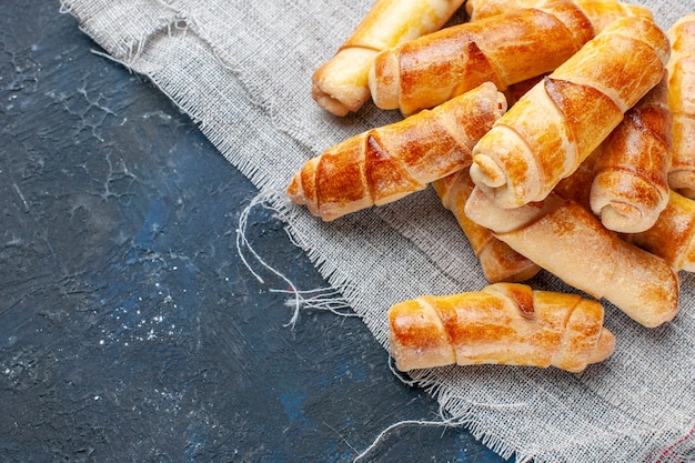 Vista ravvicinata dall'alto di deliziosi bagel dolci cotti sulla scrivania grigio scuro, cuocere lo zucchero dolce del biscotto della pasticceria della pasta