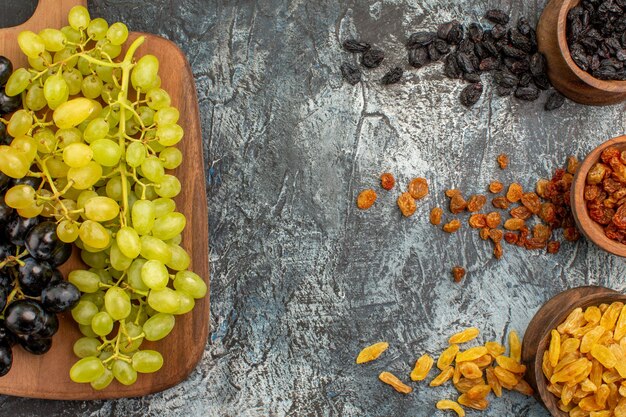 Vista ravvicinata dall'alto frutta secca frutta secca colorata l'uva appetitosa sul tagliere