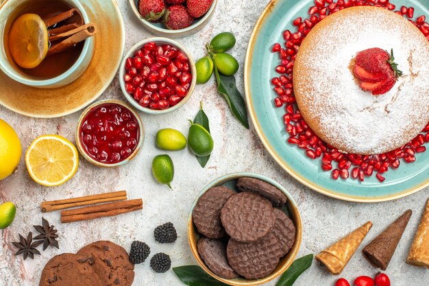 Vista ravvicinata dall'alto frutti di bosco e tè al limone alla cannella una tazza di tè al limone la torta ai frutti di bosco