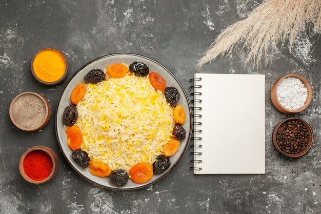 Vista ravvicinata dall'alto piatto di riso di riso con spezie per taccuino di frutta secca