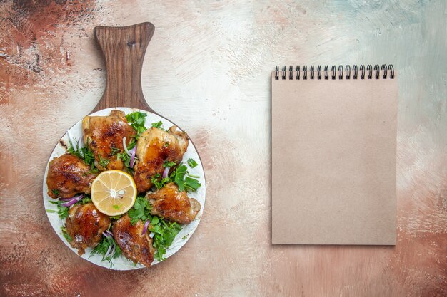 Vista ravvicinata dall'alto pollo un pollo appetitoso con erbe aromatiche al limone su lavash sul quaderno crema da tavolo