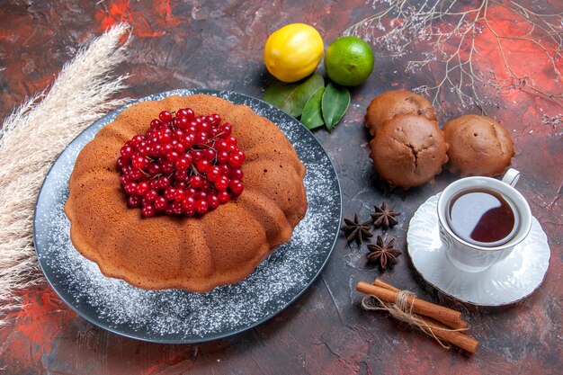 Vista ravvicinata dall'alto torta una torta appetitosa con frutti di bosco una tazza di tè agli agrumi