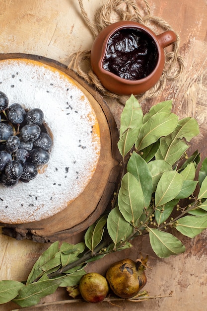 Vista ravvicinata dall'alto una torta una torta con l'uva sul bordo foglie di salsa al cioccolato