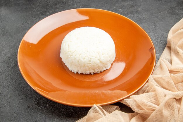 Vista ravvicinata del pasto di riso facile-preparato su un piatto marrone e un asciugamano sul nero