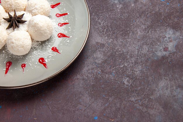 Vista ravvicinata deliziose caramelle al cocco con glasse rosse sullo spazio scuro