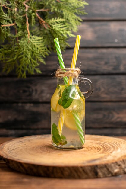 Vista ravvicinata dell'acqua detox fatta di limone e menta su fondo di legno marrone