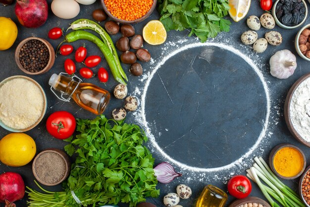 Vista ravvicinata della cena che cucina con uova verdure fresche spezie uova bottiglia di olio caduta fasci verdi bottiglia di olio caduta