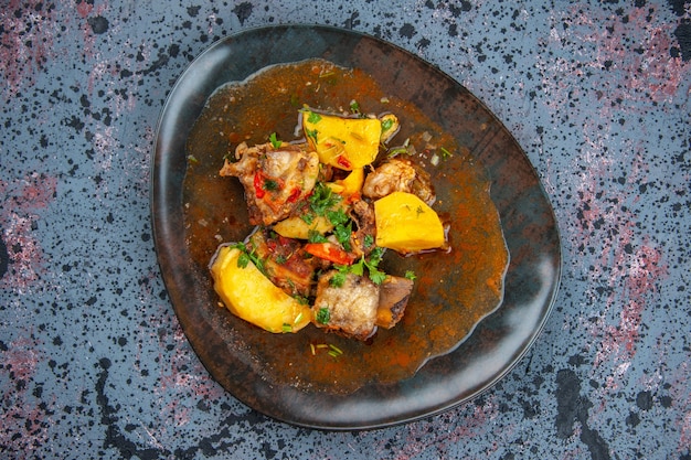 Vista ravvicinata della deliziosa cena con patate a base di carne servite con verde su sfondo di colori della miscela