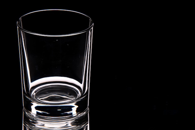 Vista ravvicinata della tazza di vetro vuota sul lato destro su sfondo scuro con spazio libero