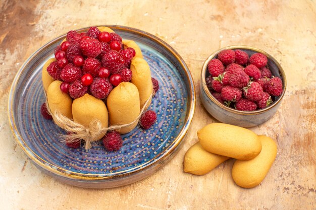 Vista ravvicinata della torta morbida appena sfornata con frutta e biscotti sulla tavola di colori misti