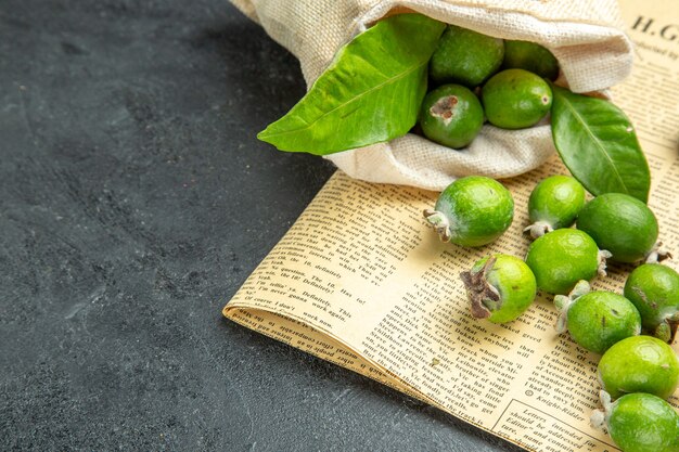 Vista ravvicinata di feijoas verdi freschi naturali da una borsa bianca caduta