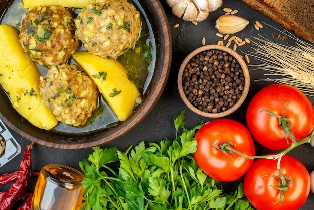 Vista ravvicinata di gustose polpette di verdure fresche uova pepe verde bottiglia di olio caduto picchi su sfondo nero