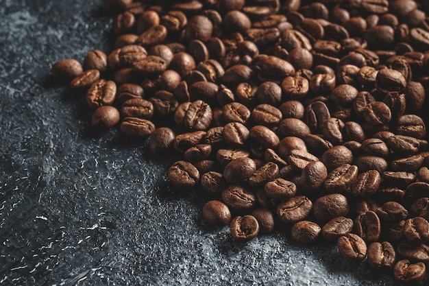 Vista ravvicinata di semi di caffè marrone su oscurità
