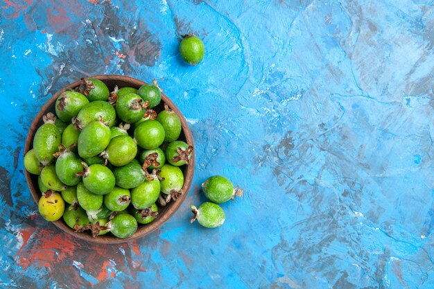 Vista ravvicinata di una piccola bomba vitaminica verde feijoas freschi in un vaso marrone