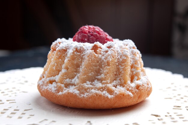 Vista ravvicinata frontale deliziosa torta con panna e lampone rosso sullo zucchero del biscotto di frutta torta superficie scura