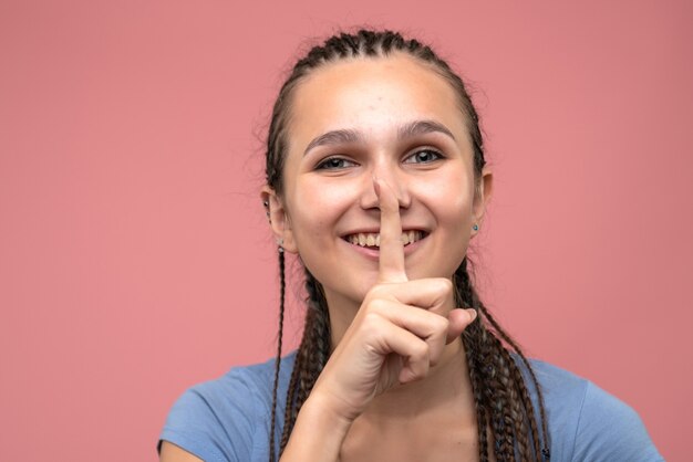 Vista ravvicinata frontale della ragazza sorridente sul rosa chiaro