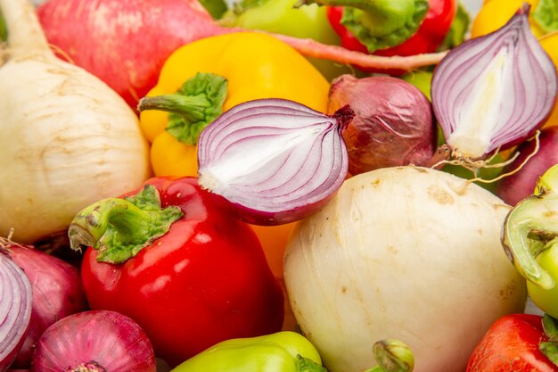 Vista ravvicinata frontale peperoni freschi su verdura bianca pepe colore maturo foto insalata pasto sano