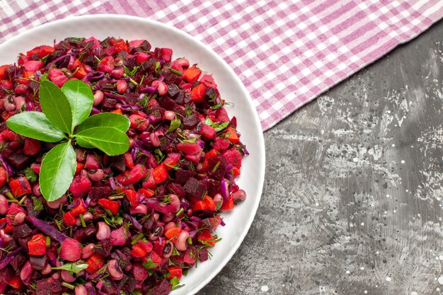 Vista ravvicinata gustosa insalata di barbabietola vinaigrette all'interno della piastra su sfondo scuro