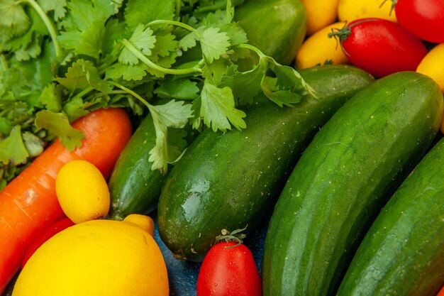 Vista ravvicinata in basso frutta e verdura prezzemolo pomodorini cumcuats cetrioli limone carota