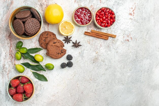 Vista ravvicinata laterale biscotti e frutti di bosco biscotti fragole agrumi sul tavolo