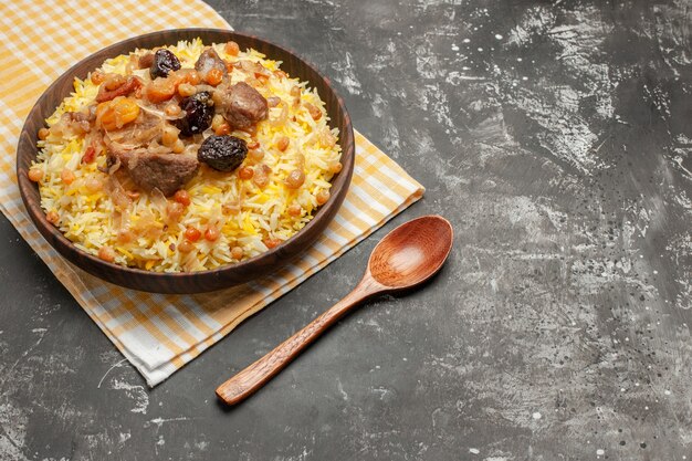 Vista ravvicinata laterale cucchiaio pilaf un appetitoso pilaf sulla tovaglia a scacchi