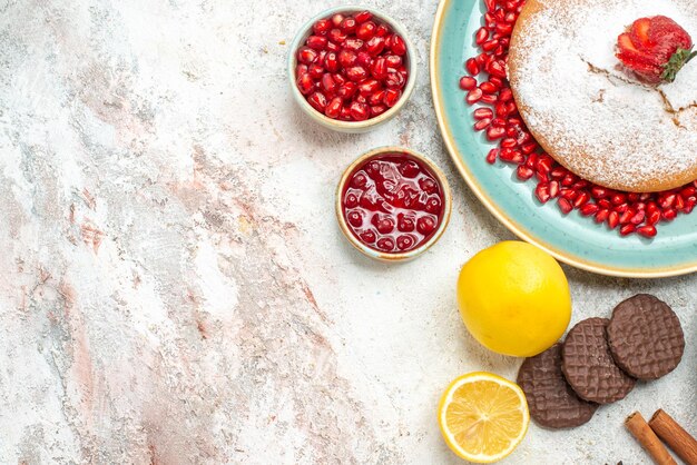 Vista ravvicinata laterale la torta appetitosa biscotti al limone marmellata cannella una tazza di tè e la torta