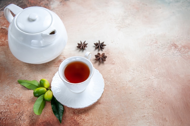 Vista ravvicinata laterale una tazza di tè bianco teiera una tazza di tè anice stellato agrumi