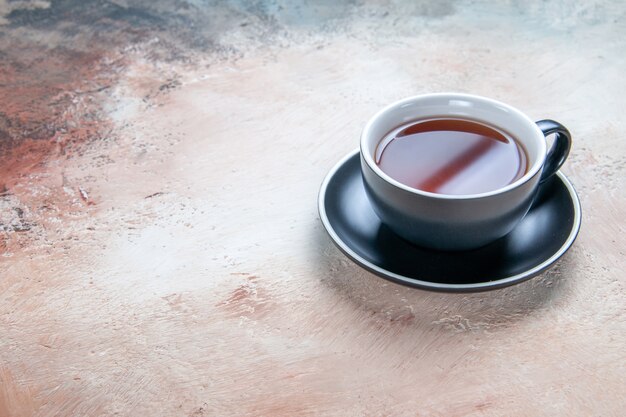 Vista ravvicinata laterale una tazza di tè nero tazza di tè sul piattino