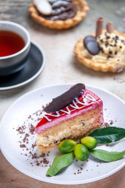 Vista ravvicinata laterale una torta una torta agli agrumi una tazza di tè cupcakes cannella anice stellato