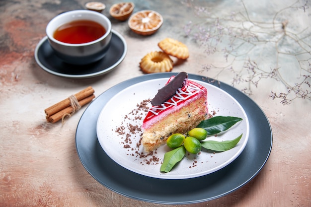 Vista ravvicinata laterale una torta una torta con agrumi al cioccolato una tazza di tè biscotti alla cannella