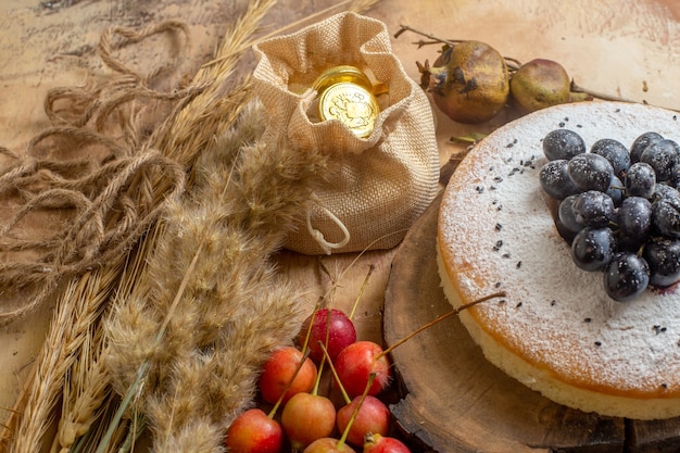 Vista ravvicinata laterale una torta una torta con le spighette di caramelle bacche di uva