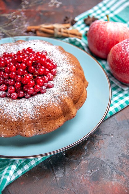 Vista ravvicinata laterale una torta una torta con mele di ribes rosso sulla tovaglia cannella anice stellato