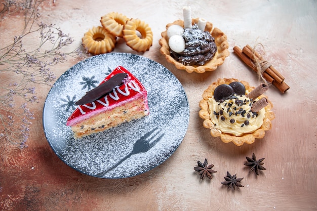 Vista ravvicinata laterale una torta una torta cupcakes cannella bastoni taccuino di biscotti all'anice stellato