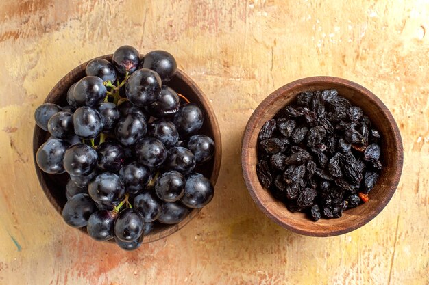 Vista ravvicinata superiore dell'uva ciotole di uvetta e uva nera sul tavolo