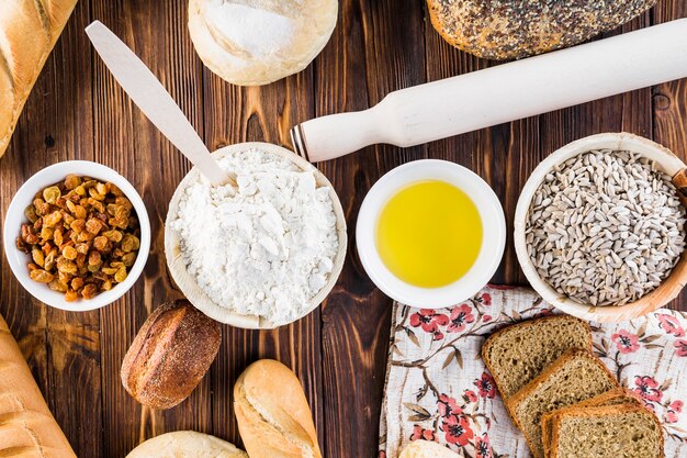 Vista sopraelevata degli ingredienti del forno del pane con il matterello su fondo di legno