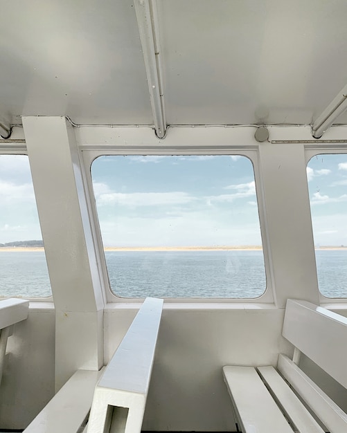 Vista sul mare dalla finestra di uno yacht con interni bianchi
