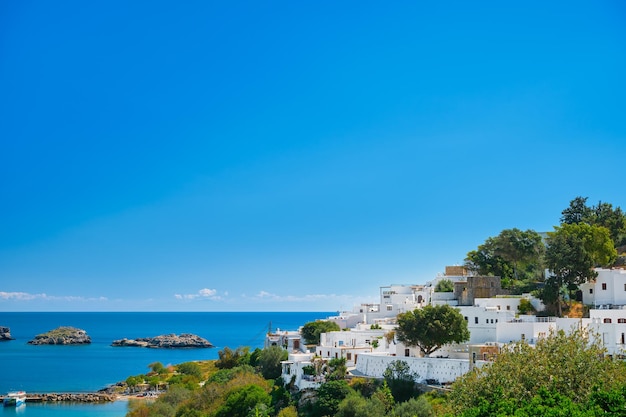 Vista sulla baia e sulle case bianche come la neve dell'antica città di Lindos sull'isola greca di Rodi vista sul Mar Egeo le isole dell'arcipelago del Dodecaneso Europa