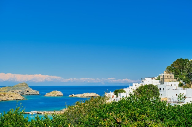 Vista sulla baia e sulle case bianche come la neve dell'antica città di Lindos sull'isola greca di Rodi vista sul Mar Egeo le isole dell'arcipelago del Dodecaneso Europa