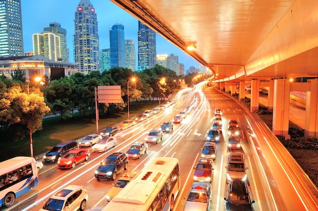 Vista sulla strada di Shanghai con scena urbana e traffico intenso al crepuscolo.