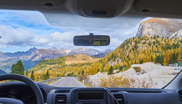 Vista sulle Alpi attraverso il parabrezza dell'auto durante la guida su strade curve