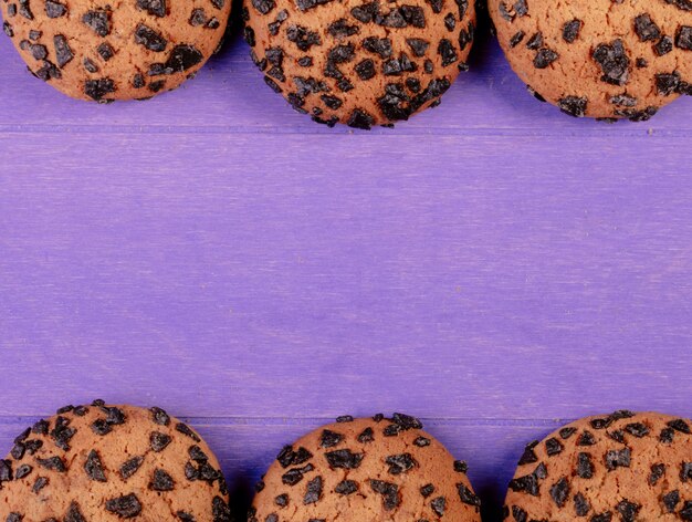 Vista superiore dei biscotti di farina d'avena con cioccolato su fondo di legno porpora con lo spazio della copia