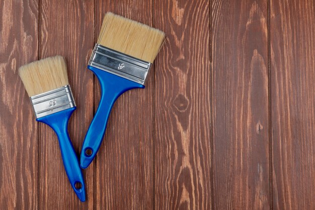 Vista superiore dei pennelli su fondo di legno con lo spazio della copia