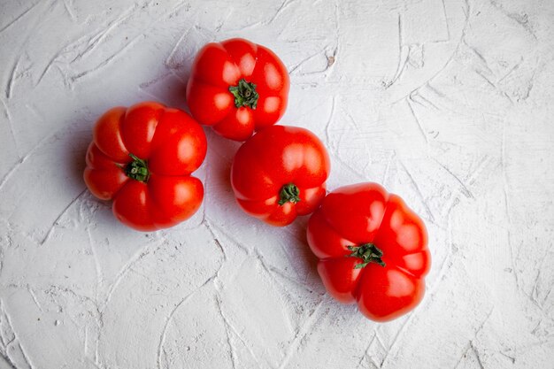 Vista superiore dei pomodori su una priorità bassa strutturata bianca