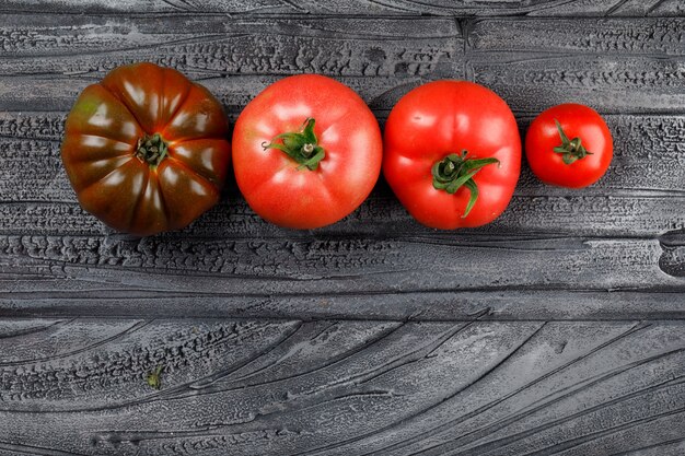 Vista superiore dei pomodori variopinti su una parete di legno grigia