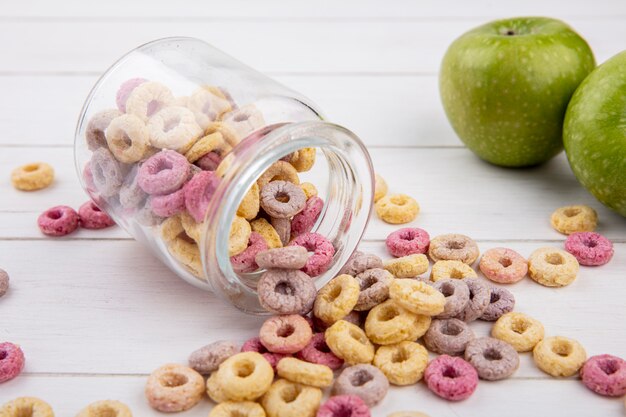 Vista superiore del ciclo sano e cereali colorati su un barattolo di vetro con la mela verde su superficie bianca