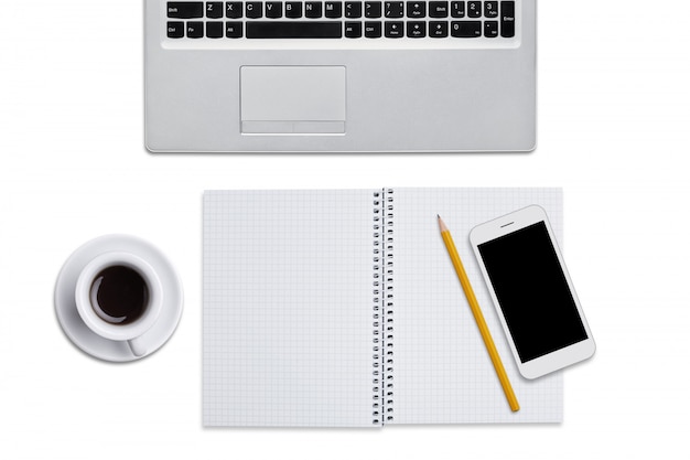 Vista superiore del computer portatile, del blocco note a spirale con la matita, dello Smart Phone e della tazza di caffè isolati sopra fondo bianco. Posto di lavoro dell'uomo d'affari
