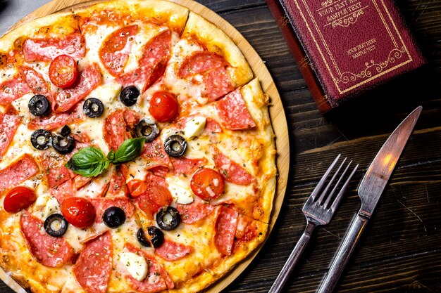 Vista superiore del formaggio del basilico delle olive del pomodoro della pizza del salame