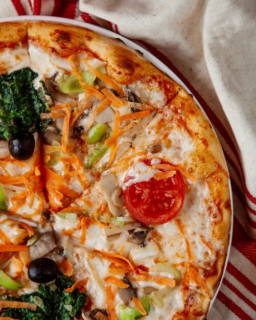 vista superiore del formaggio vegetariano del fungo del pomodoro del peperone dolce degli spinaci della carota della pizza