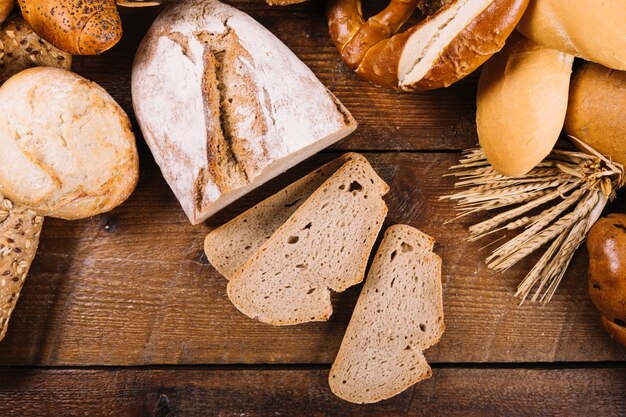 Vista superiore del pane intero affettato sulla tavola di legno