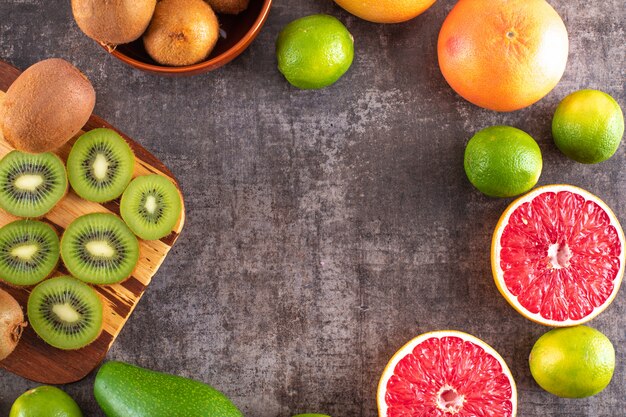 Vista superiore dell'avocado e dei frutti di arancio del pompelmo del kiwi con lo spazio della copia sulla superficie del nero